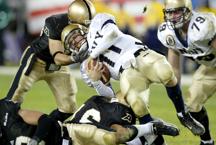 An unidentified Army defender pulls down Navy quarterback Craig Candeto (11)  in the third quarter the 104th Army-Navy football game, Dec. 6, 2003. (AP/Rusty Kennedy)