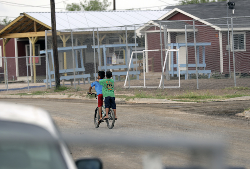 Young boys ride a bike through the Indian Hills East Colonia near Alamo, Texas. (AP/Eric Gay)