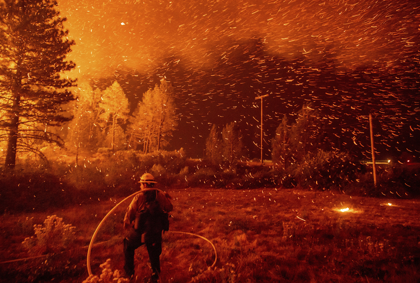 Embers fly above a firefighter as he works to control a backfire as the Delta Fire burns in the Shasta-Trinity National Forest, Calif., on Sept. 6, 2018. (AP/Noah Berger)