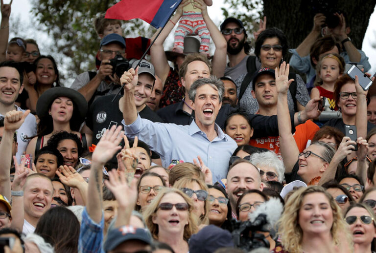 U.S. Senate candidate Rep. Beto O'Rourke (D-TX) holds a Texas flag as he poses for a group photo with supporters during a campaign rally in Mueller Lake Park October 31, 2018 in Austin, Texas. (Getty/Chip Somodevilla)