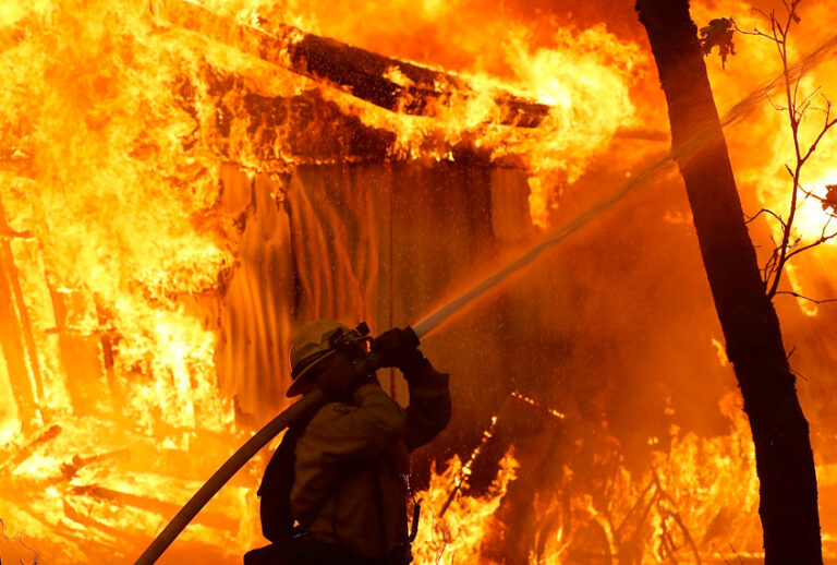 A Cal Fire firefighter monitors a burning home as the Camp Fire moves through the area on November 9, 2018 in Magalia, California. (Getty/Justin Sullivan)