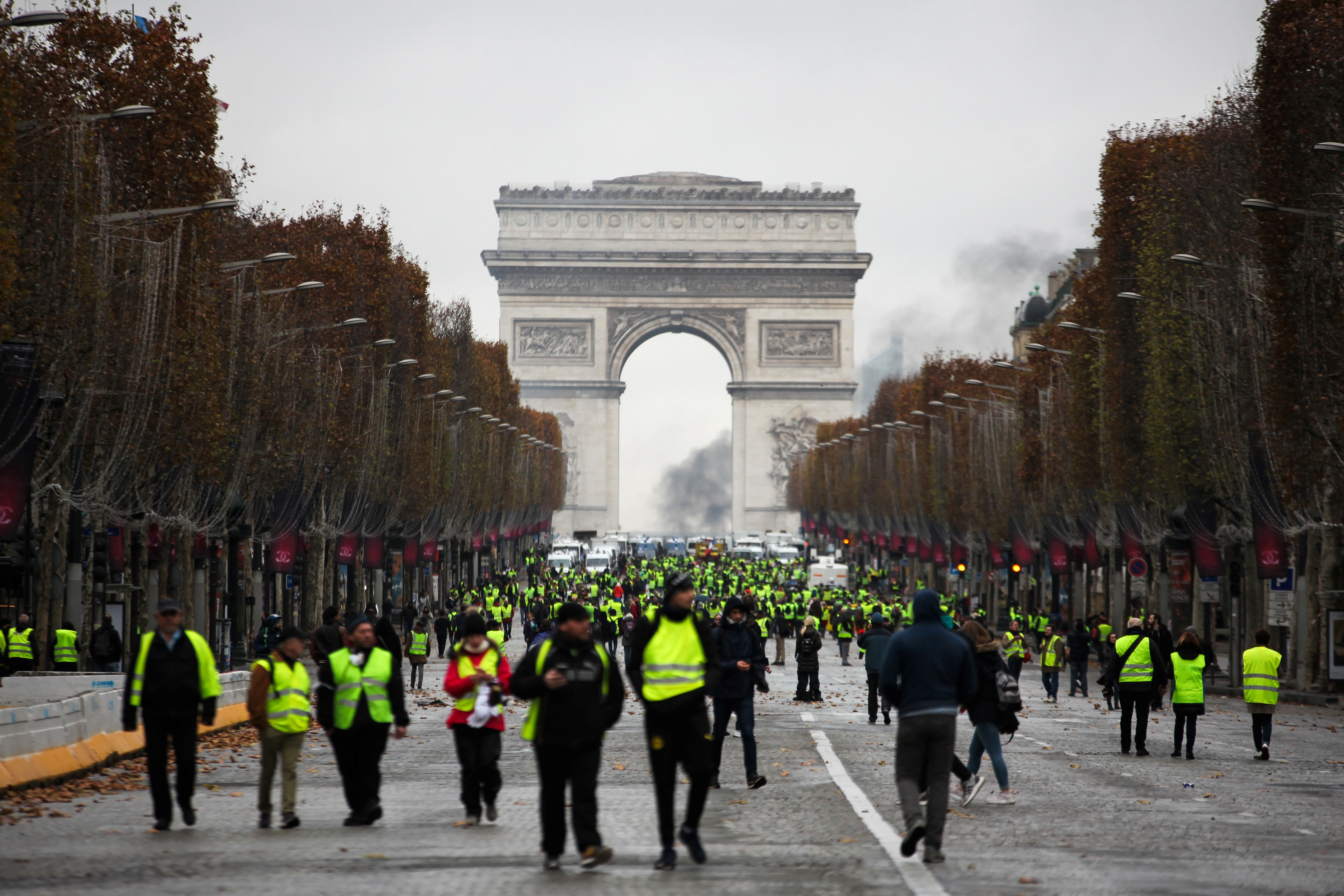 Demonstrators walk near the Arc de Triomphe during a protest of "yellow vests." (Gilets jaunes) against rising oil prices and living costs, on December 1, 2018 in Paris. - Anti-government protesters torched dozens of cars and set fire to storefronts during daylong clashes with riot police across central Paris on December 1, as thousands took part in fresh "yellow vest" protests against high fuel taxes. (Afp/getty Images)
