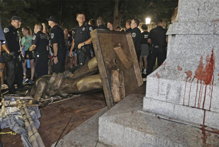 FILE - In this Aug. 20, 2018, file photo, police stand guard after the confederate statue known as Silent Sam was toppled by protesters on campus at the University of North Carolina in Chapel Hill, N.C. Leaders of North Carolina’s flagship university are meeting to decide the fate of a Confederate monument torn down by protesters. The chancellor and trustees of the University of North Carolina at Chapel Hill were finalizing a plan Monday, Dec. 3, for the century-old bronze statue known as “Silent Sam.” (AP Photo/Gerry Broome, File) (AP)
