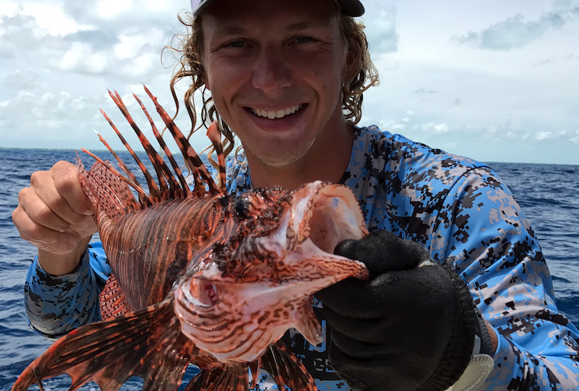Forever Young Charter Company captain Tony Young, holding a lionfish. (Courtesy of Forever Young/Civil Eats)