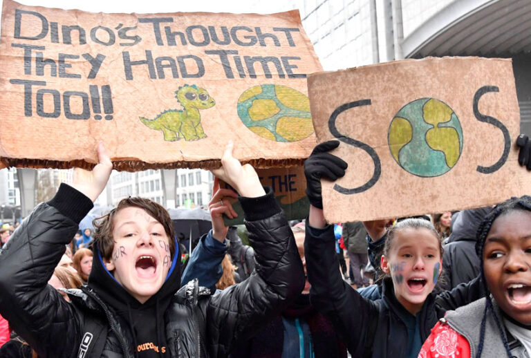 Protestors hold placards as they march during a Rise for the Climate demonstration in Brussels, Sunday, Jan. 27, 2019. (AP/Geert Vanden Wijngaert)