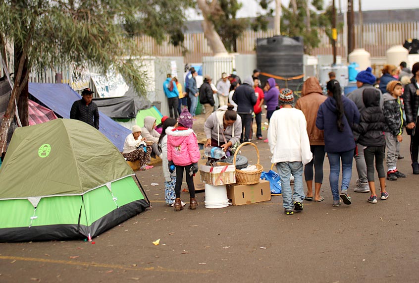 A mother pours water to cook breakfast at the the central migrant camp in Tijuana. (Marc Licciardi)