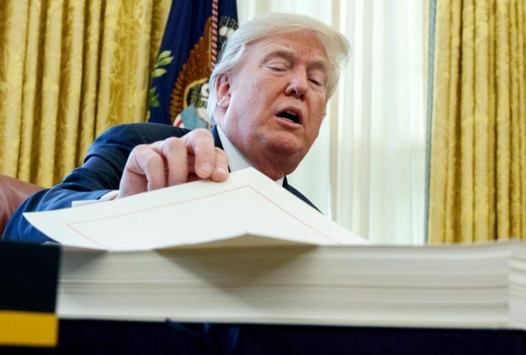 Donald Trump prepares to sign the tax bill in the Oval Office of the White House, Friday, Dec. 22, 2017, in Washington. (AP/Evan Vucci)
