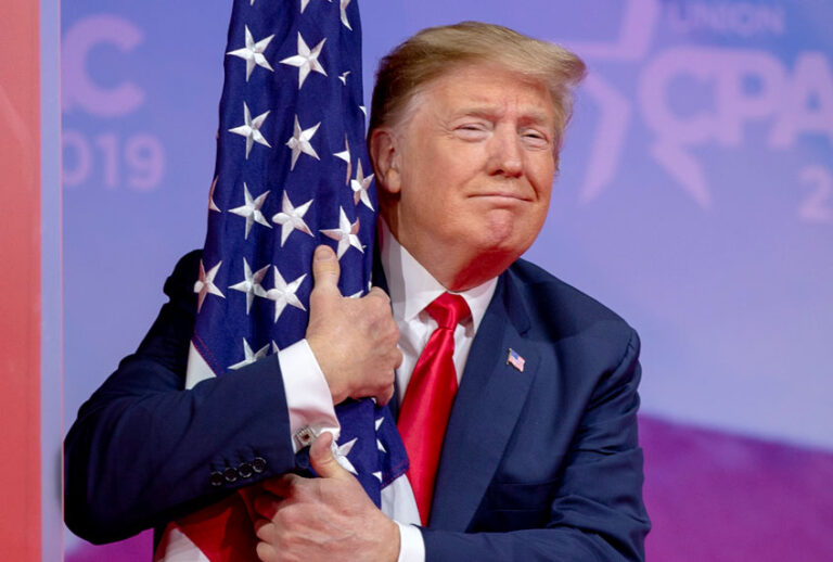 Donald Trump hugs the U.S. flag during CPAC 2019 on March 02, 2019 in National Harbor, Maryland. (Getty/Tasos Katopodis)