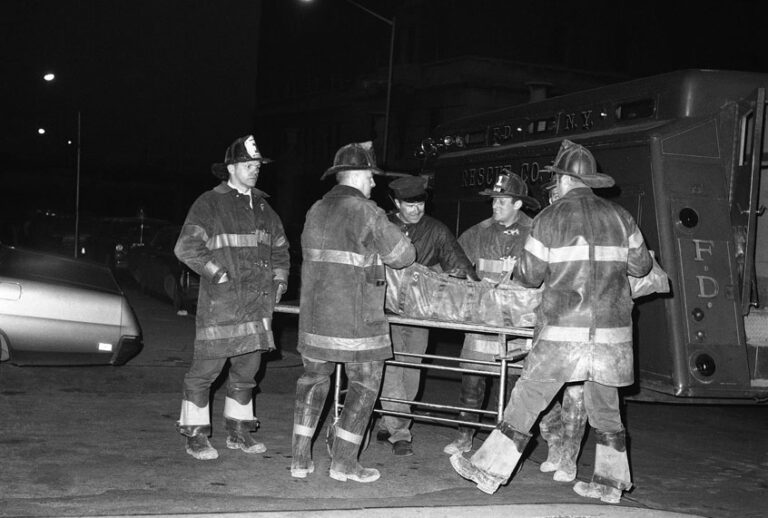Firefighters place the body of a third victim of the Greenwich Village townhouse explosion on a cart at New York's Bellevue Hospital, March 14, 1970. (AP Photo/TC)