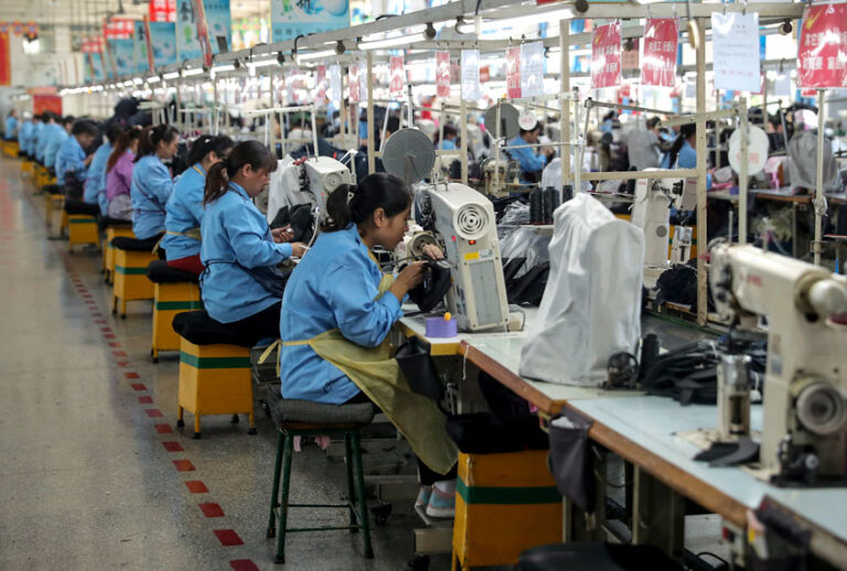 This photo taken on October 17, 2018 shows workers sewing shoes at a factory in Qingdao in China's eastern Shandong province (STR/AFP/Getty)