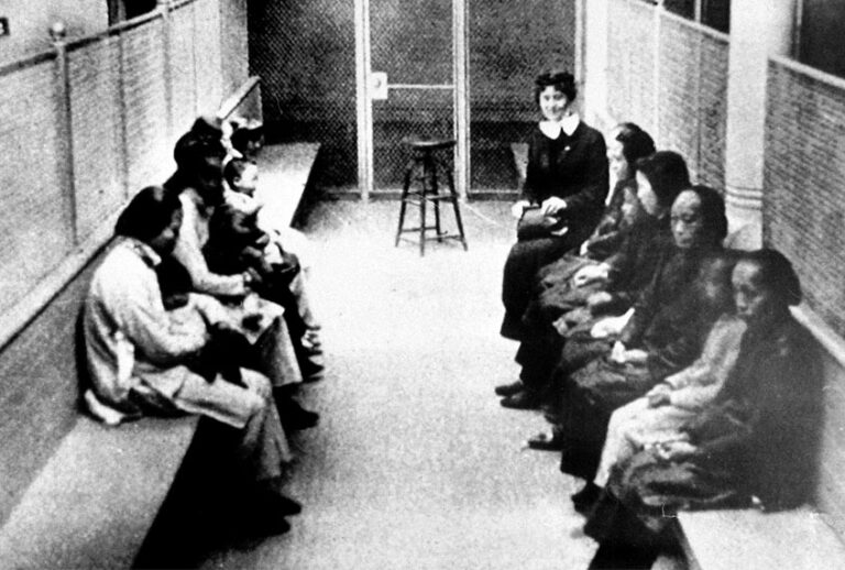 A group of Chinese and Japanese women and children wait to be processed as they are held in a wire mesh enclosure at the Angel Island Internment barracks in San Francisco Bay in the late 1920s. (AP Photo)