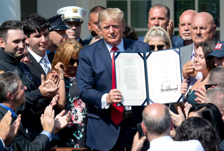 People applaud as US President Donald Trump, surrounded by September 11 first responders and family members, signs HR 1327, an act to permanently authorize the September 11th victim compensation fund, during a ceremony in the Rose Garden of the White House in Washington, DC, July 29, 2019. (Getty/Saul Loeb)