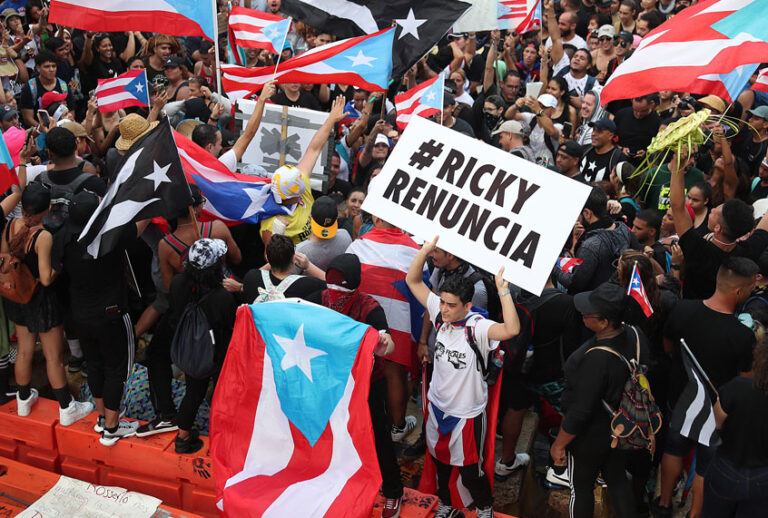 Protesters demonstrate against Ricardo Rossello, the Governor of Puerto Rico, near police that are manning a barricade set up along a street leading to the governor's mansion on July 22, 2019 in Old San Juan, Puerto Rico. (Getty/Joe Raedle)