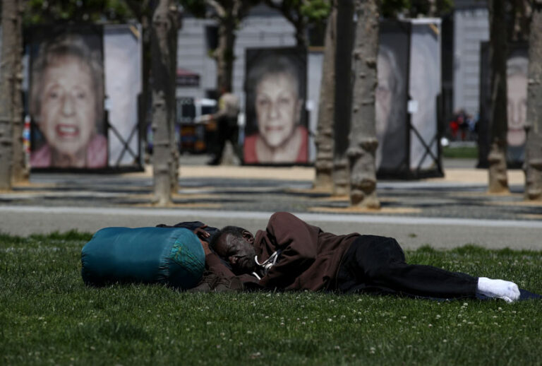 A homeless man sleeps on the grass at Civic Center Plaza on May 17, 2019 in San Francisco, California. (Getty/Justin Sullivan)