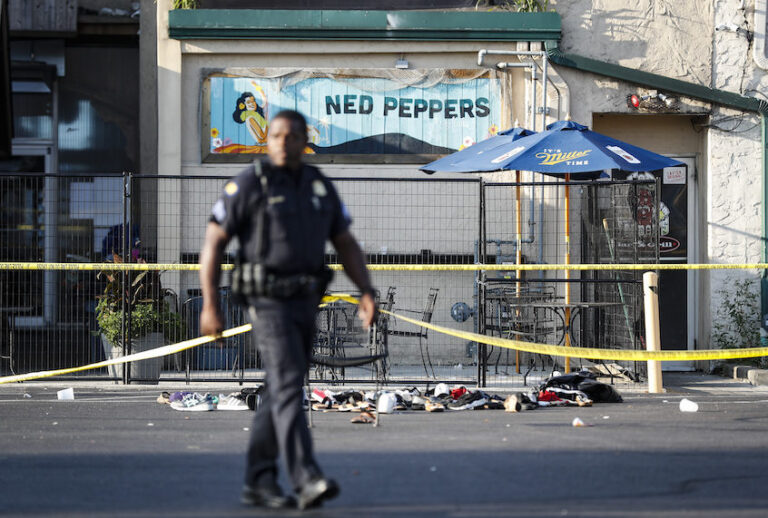 Shoes are piled outside the scene of a mass shooting including Ned Peppers bar, Sunday, Aug. 4, 2019, in Dayton, Ohio. (AP/John Minchillo)