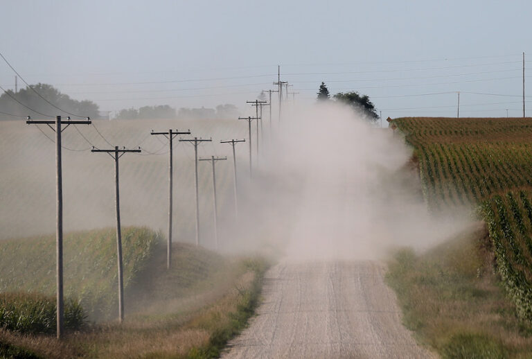 A car kicks up dust as it drives by corn fields on August 7, 2012 in State Center, Iowa. (Justin Sullivan/Getty Images)