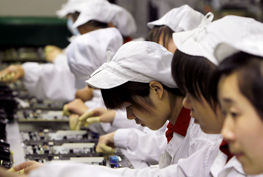 In this May 26, 2010 file photo, staff members work on the production line at the Foxconn complex in the southern Chinese city of Shenzhen, southern China. (AP Photo/Kin Cheung)