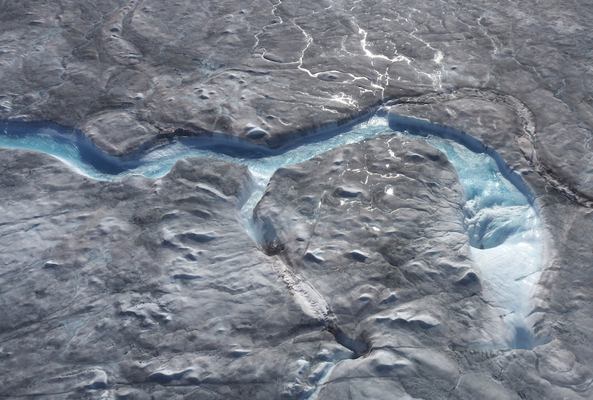 In this image taken on Thursday Aug.1, 2019 large rivers of melting water form on an ice sheet in western Greenland and drain into moulin holes that empty into the ocean from underneath the ice. (Photo via Caspar Haarløv, Into the Ice via AP)