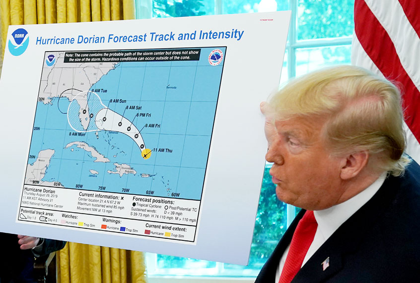 U.S. President Donald Trump (R) references a map while talking to reporters following a briefing from officials about Hurricane Dorian in the Oval Office at the White House September 04, 2019 in Washington, DC. (Chip Somodevilla/Getty Images)