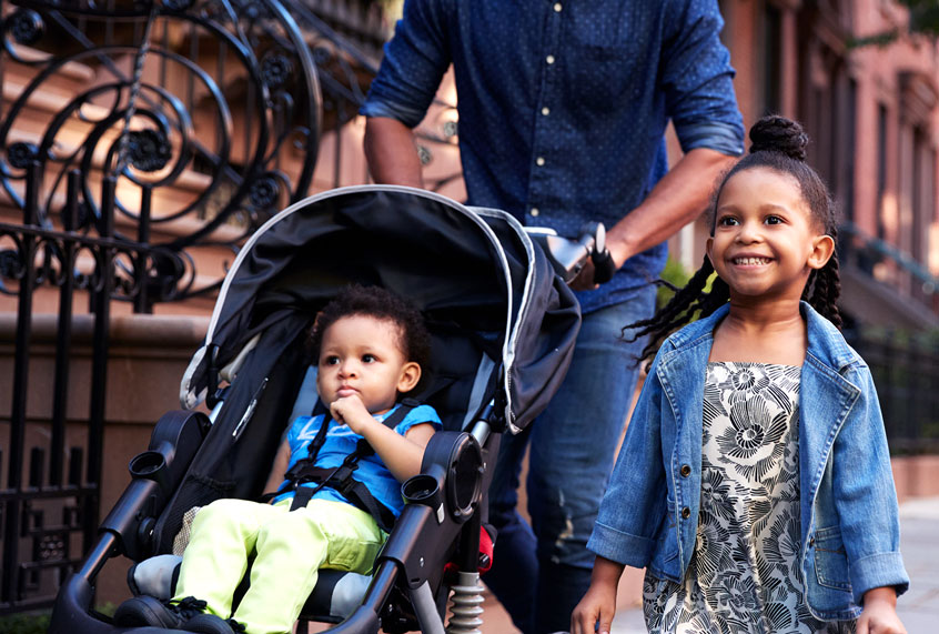 Father and two daughters taking a walk down the street (Getty Images)