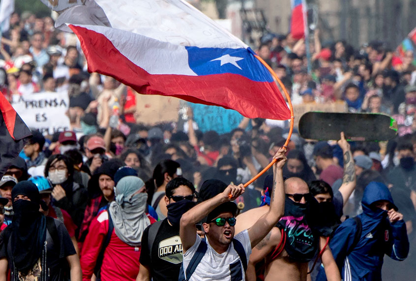 People demonstrate at Plaza Italia on the fifth straight day of street violence which erupted over a now suspended hike in metro ticket prices, in Santiago on October 22, 2019. - President Sebastian Pinera convened a meeting with leaders of Chile's political parties on Tuesday in the hope of finding a way to end street violence that has claimed 15 lives, as anti-government campaigners threatened new protests. (PEDRO UGARTE/AFP via Getty Images)
