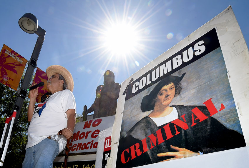 Olin Tezcatlipoca from the Mexica Movement speaks to demonstrators in front of a statue of Christopher Columbus during a protest against Columbus Day in Grand Park, Los Angeles, California on October 11, 2015. The Mexica Movement is amongst a growing group of people and US cities that want change the name of the 'Columbus Day' holiday to 'Indigenous Peoples Day. (MARK RALSTON/AFP/Getty Images)
