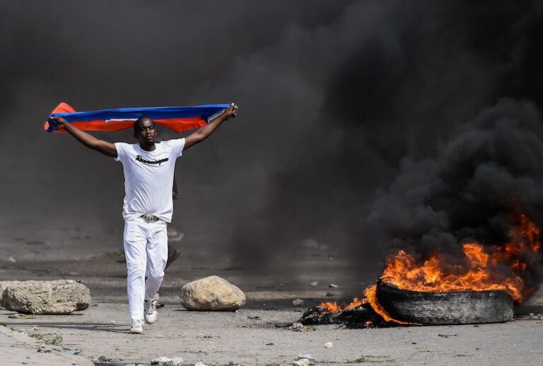 A demonstrator waves a Haitian flag during a protest outside United Nation's main base, against President Jovenel Moise on October 4, 2019 in Port-au-Prince, Haiti. (Chandan Khanna//AFP via Getty Images)