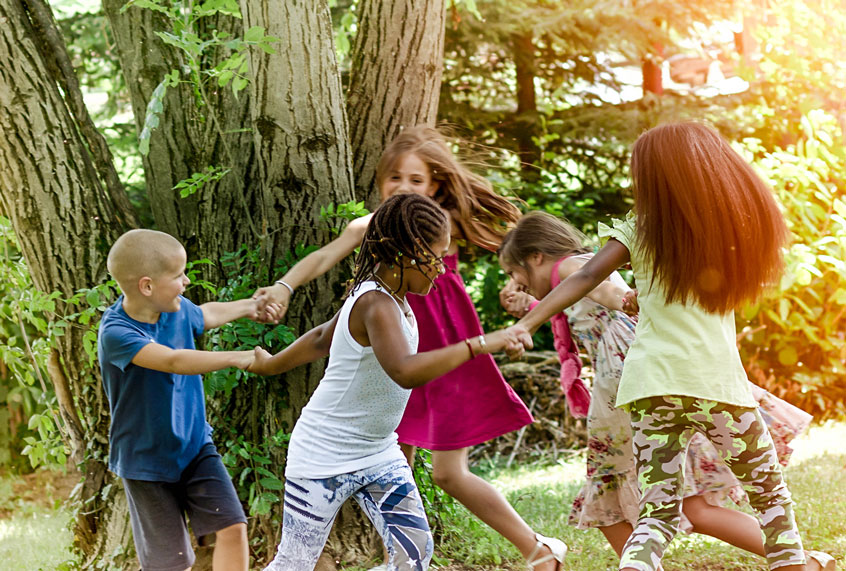 Children holding hands and running through the park. (Getty Images)