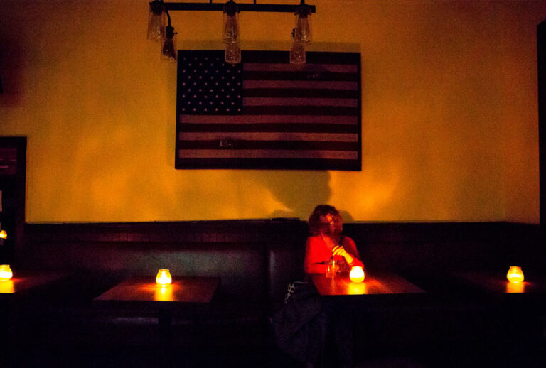 Judy Aquiline, a Sonoma local, sits in the candle-lit restaurant Reel and Brand in Sonoma, California, on October 9, 2019, during a planned power outage by the Pacific Gas & Electric (PG&E) utility company. - Rolling blackouts set to affect millions of Californians began on October 9 as a utility company started switching off power to an unprecedented number of households in the face of hot, windy weather that raises the risk of wildfires. (BRITTANY HOSEA-SMALL/AFP via Getty Images)