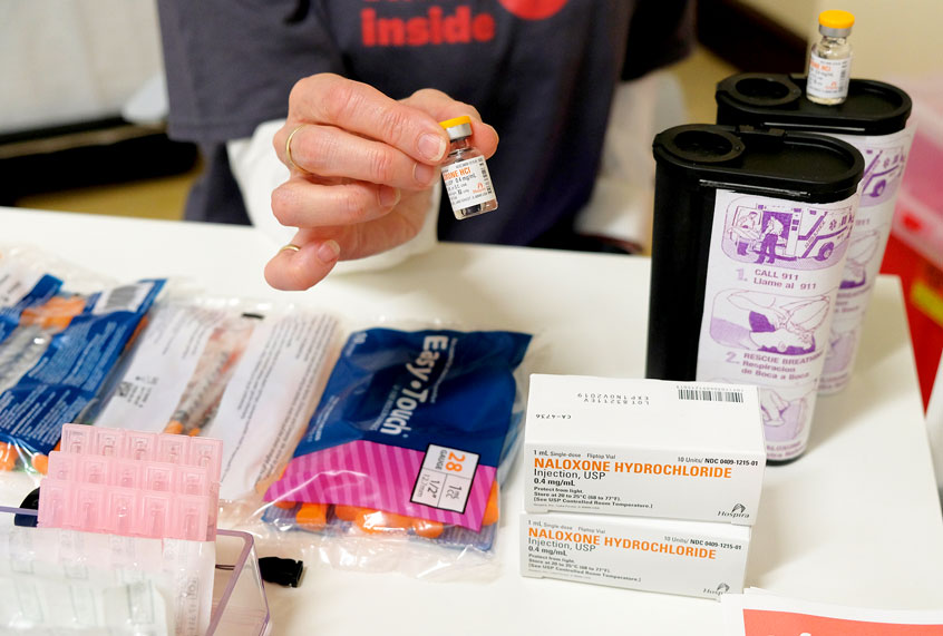 In this photo taken Wednesday, Aug. 29, 2018, Linda Montel shows off supplies on a check in desk at Safer Inside, a realistic model of a safe injection site in San Francisco. The model is an example of a supervised, indoor location where intravenous drug users can consume drugs in safer conditions and access treatment and recovery services. (AP Photo/Eric Risberg)