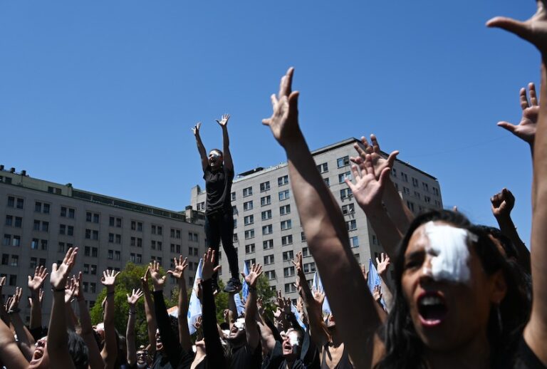 Demonstrators raise their hands as they perform against police violence after several demonstrators were injured in their eyes with pellets, outside La Moneda presidential palace in Santiago on November 12, 2019. (Rodrigo Arangua/Afp Via Getty Images)