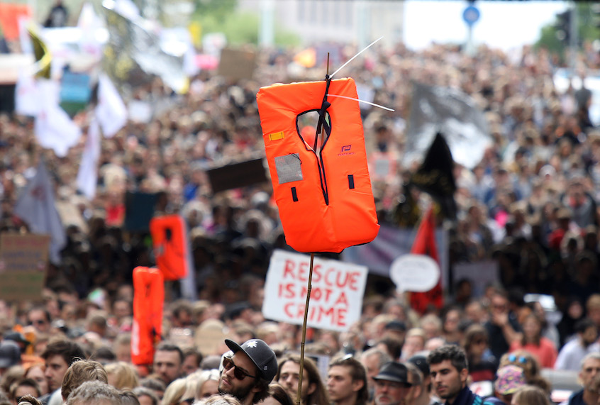 Supporters of the NGO Sea-Watch hold flags and rescue blankets during a demonstration in solidarity with the German captain of rescue vessel Sea-Watch 3, Carola Rackete, on July 6, 2019 outside the Chancellery in Berlin. (Omer Messinger/AFP via Getty Images)