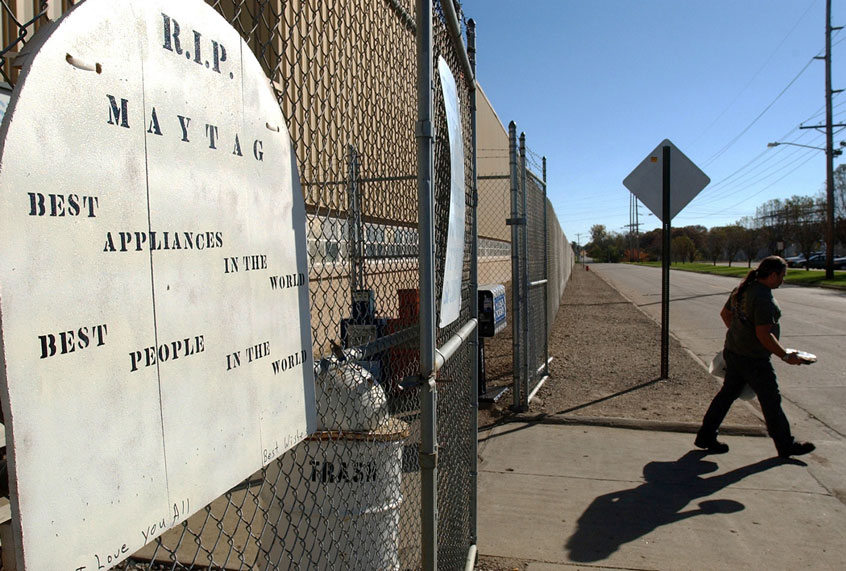 A R.I.P. sign hangs on the gate as a worker exits the plant on the eve of the final day of production at the Maytag plant in Newton, Iowa (AP Photo/Steve Pope)