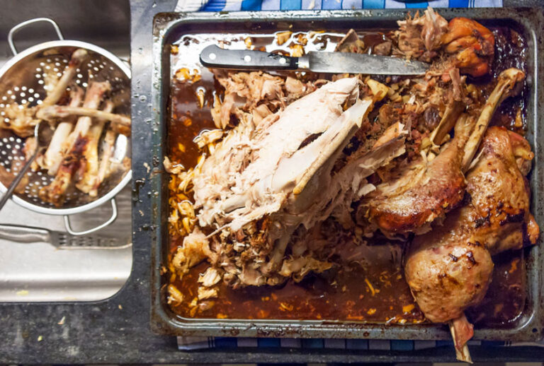 Leftover carcass and bones from a Thanksgiving turkey on an oven tray at the kitchen counter. (Getty Images)