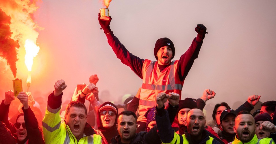 A protester holds a flare as public and private workers demonstrate and shout slogans during a mass strike against pension reforms on Dec. 5, 2019 in Marseille, France. (Arnold Jerocki/Getty Images)
