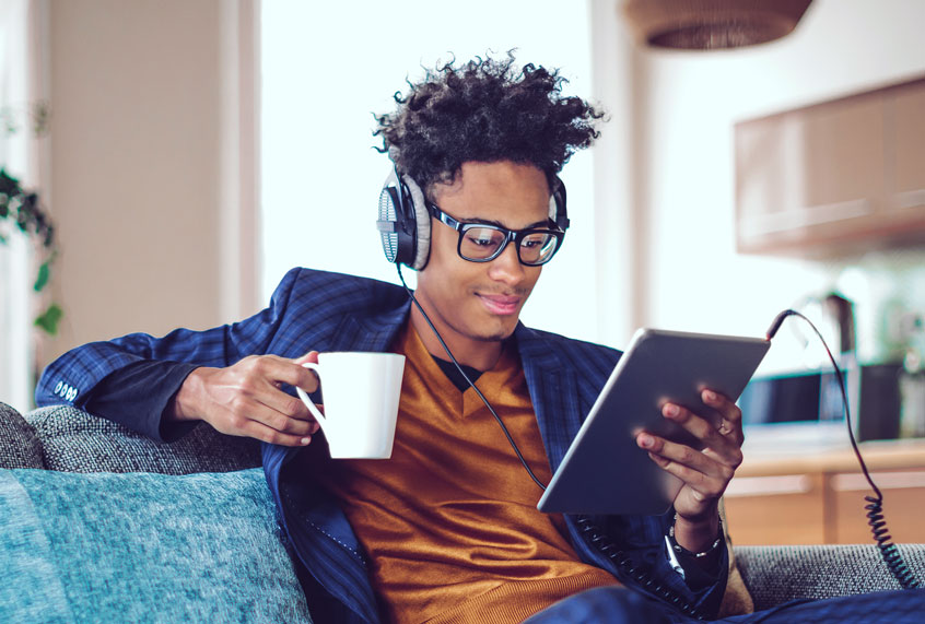 A young man listening to a podcast on headphones (Getty Images/Eva-Katalin)