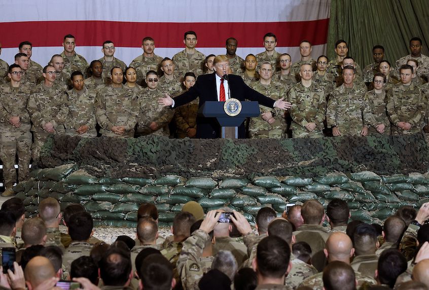 In this file photo taken on November 28, 2019, US President Donald Trump speaks to the troops during a surprise Thanksgiving day visit at Bagram Air Field in Afghanistan. (Olivier Douliery/AFP via Getty Images)