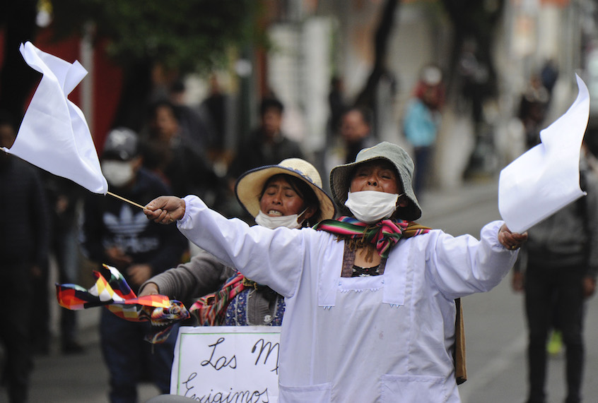 A supporters of Bolivian ex-President Evo Morales waves white flags during clashes with riot police following a protest in La Paz on November 13, 2019. - Bolivia's exiled ex-president Evo Morales said Wednesday he was ready to return to "pacify" his country amid weeks of unrest that led to his resignation. (Photo by JORGE BERNAL / AFP) (Photo by JORGE BERNAL/AFP via Getty Images) (Jorge Bernal/AFP via Getty Images)
