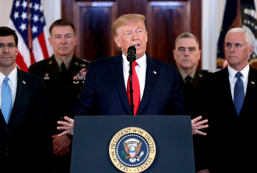 President Donald Trump addresses the nation from the White House on the ballistic missile strike that Iran launched against Iraqi air bases housing U.S. troops, Wednesday, Jan. 8, 2020, in Washington, as Vice President Mike Pence and others looks on. (AP Photo/ Evan Vucci)