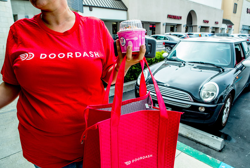 The Door Dash driver leaves Baskin Robbins, over in hand and heads to their delivery. (Getty Images/The Washington Post)
