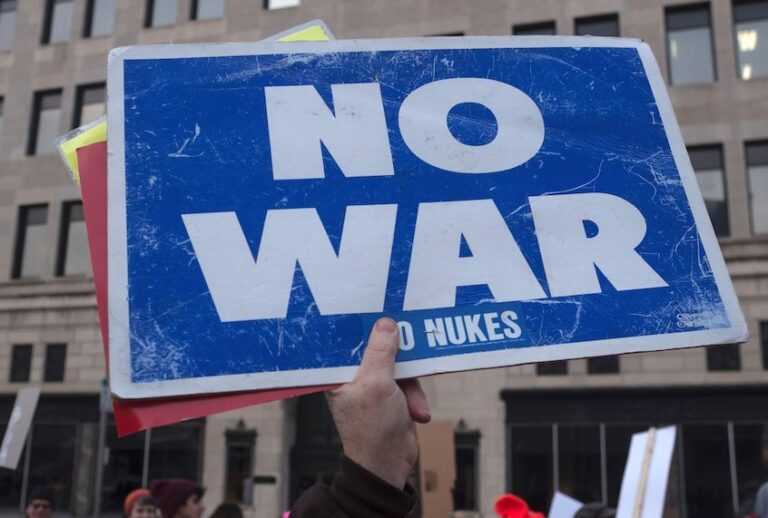 A person holds up a sign reading "now war" as protesters gather near the Huntington Center in Toledo, Ohio January 9, 2020. (Seth Herald/AFP via Getty Images)