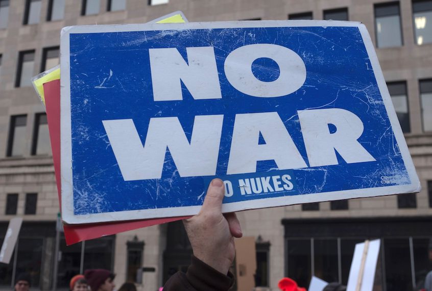 A person holds up a sign reading "now war" as protesters gather near the Huntington Center in Toledo, Ohio January 9, 2020. (Seth Herald/AFP via Getty Images)