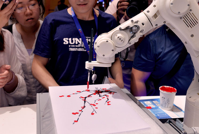 People watch an intelligent robot painting during the opening of the 3rd World Intelligence Congress (WIC) at the Meijiang Convention & Exhibition Center on May 16, 2019 in Tianjin, China. The 3rd WIC with the theme of 'Intelligence New Era: Progress, Planning and Opportunity' is held on May 16-19 in Tianjin. (Visual China Group via Getty Images)