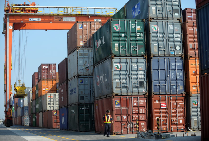 This photo taken on April 18, 2011, shows a security personnel walking past shipping containers at the International Container Terminal Services Incorporated (ICTSI) at a port in Manila. (Noel Celis/AFP via Getty)