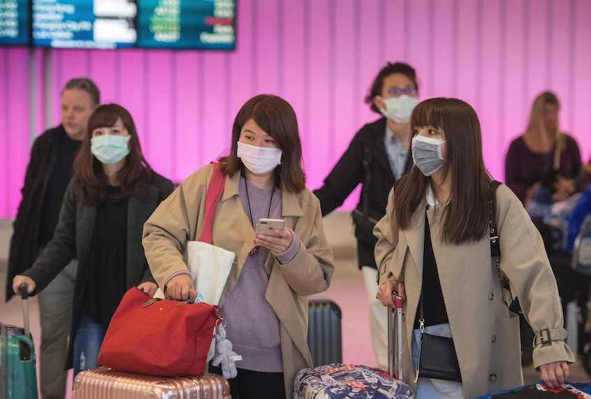 Passengers wear protective masks to protect against the spread of the Coronavirus as they arrive at the Los Angeles International Airport, California, on January 22, 2020. (Mark Ralston/AFP via Getty Images)