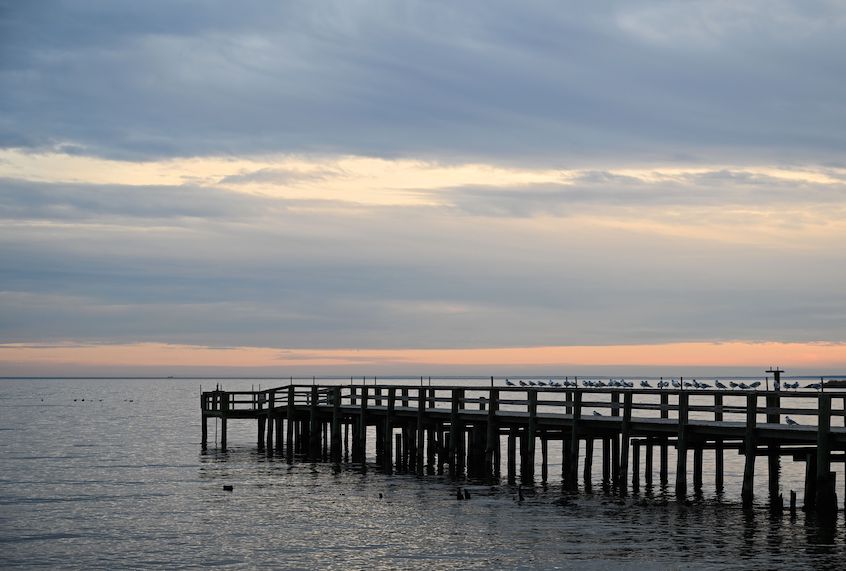 The sun sets over a fishing pier at Columbia Beach in Shady Side, Maryland, January 2, 2020. (Eva Hambach/AFP via Getty Images)