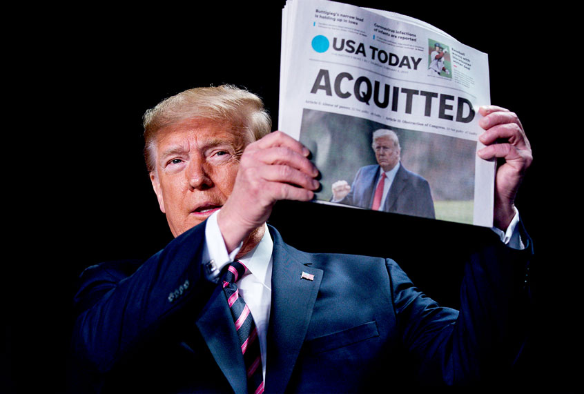 President Donald Trump holds up a newspaper with the headline that reads "ACQUITTED" at the 68th annual National Prayer Breakfast, at the Washington Hilton, Thursday, Feb. 6, 2020, in Washington. (AP Photo/ Evan Vucci)