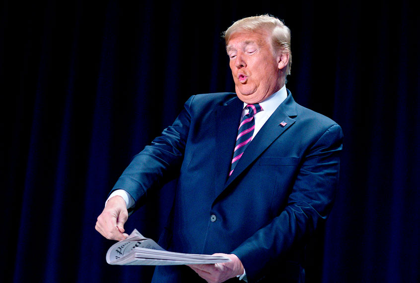 President Donald Trump reacts as he looks at the front page of a newspaper with a headline that reads "Trump acquitted" at the 68th annual National Prayer Breakfast, at the Washington Hilton, Thursday, Feb. 6, 2020, in Washington. (AP Photo/ Evan Vucci)
