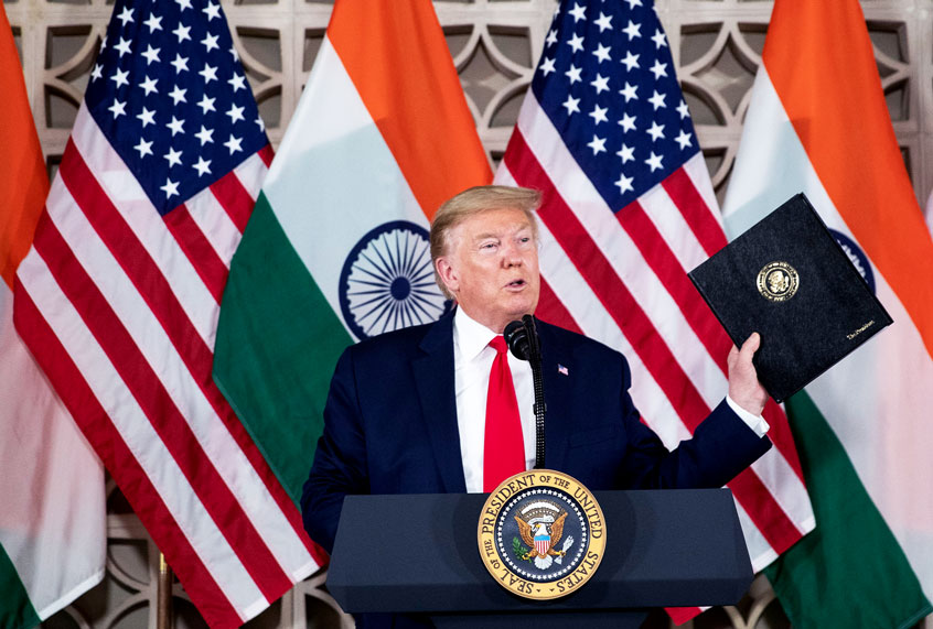 U.S.President Donald Trump holds up his prepared speech that he didn't use as he speaks with business leaders at a roundtable event at Roosevelt House, Tuesday, Feb. 25, 2020, in New Delhi, India. (AP Photo/Alex Brandon)