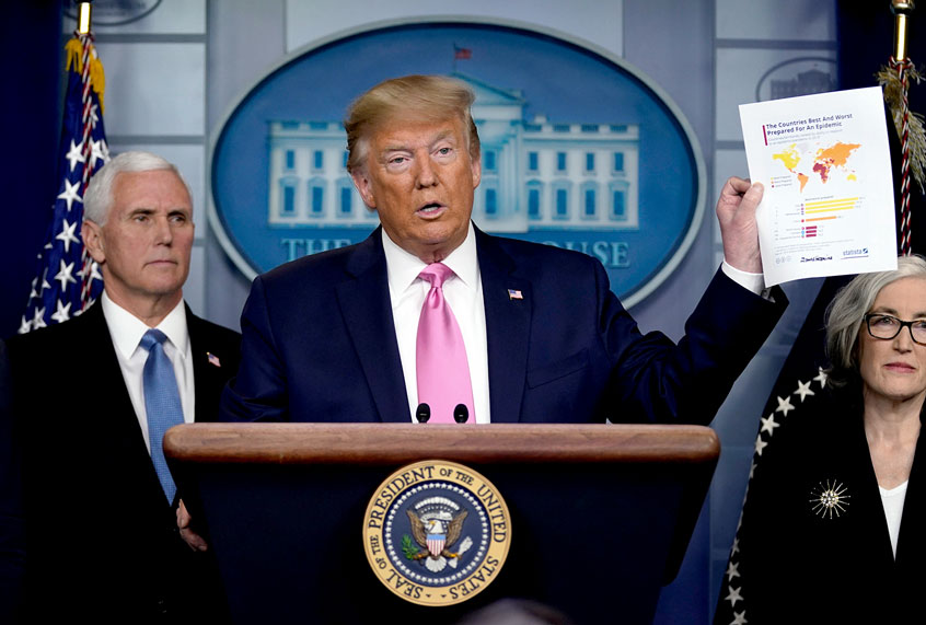 President Donald Trump, with members of the President's Coronavirus Task Force, holds a paper about countries best and least prepared to deal with a pandemic, during a news conference in the Brady Press Briefing Room of the White House, Wednesday, Feb. 26, 2020, in Washington. (AP Photo/Evan Vucci)